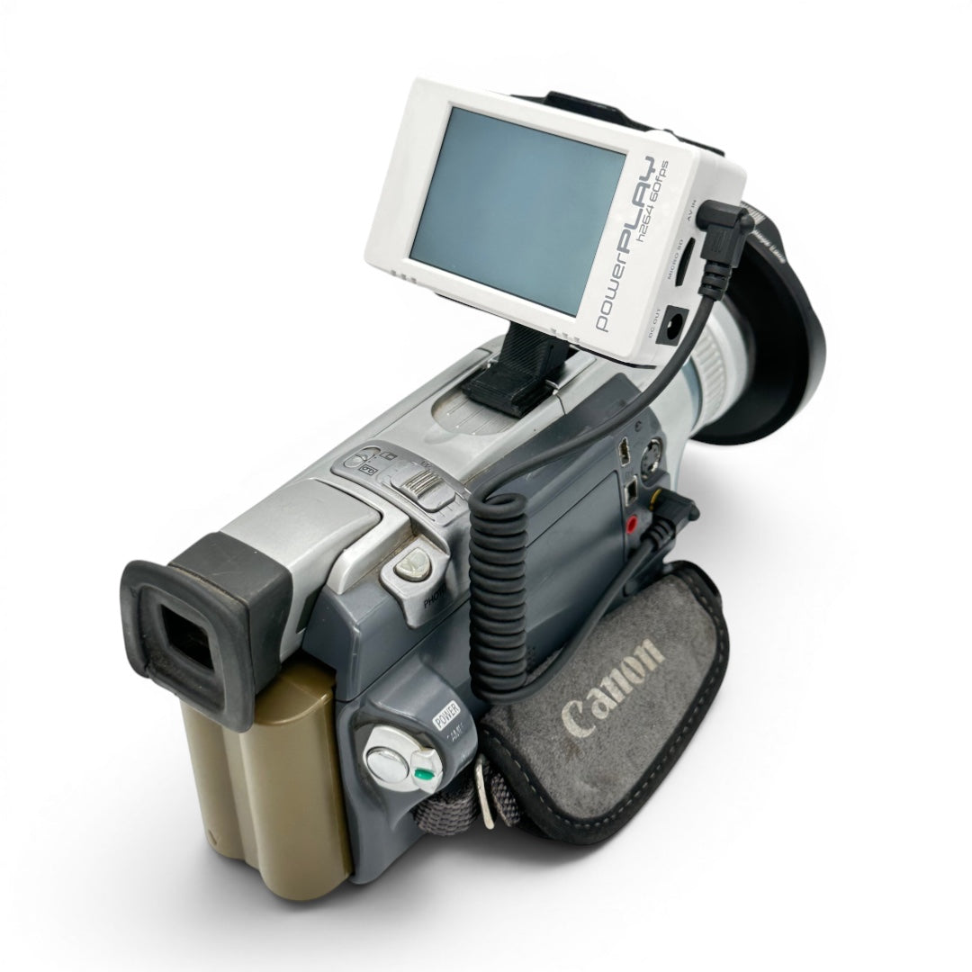 ImmersionRC PowerPlay DVR mounted on a Canon camcorder using the head strap clip, connected via the 3.5mm A/V cable